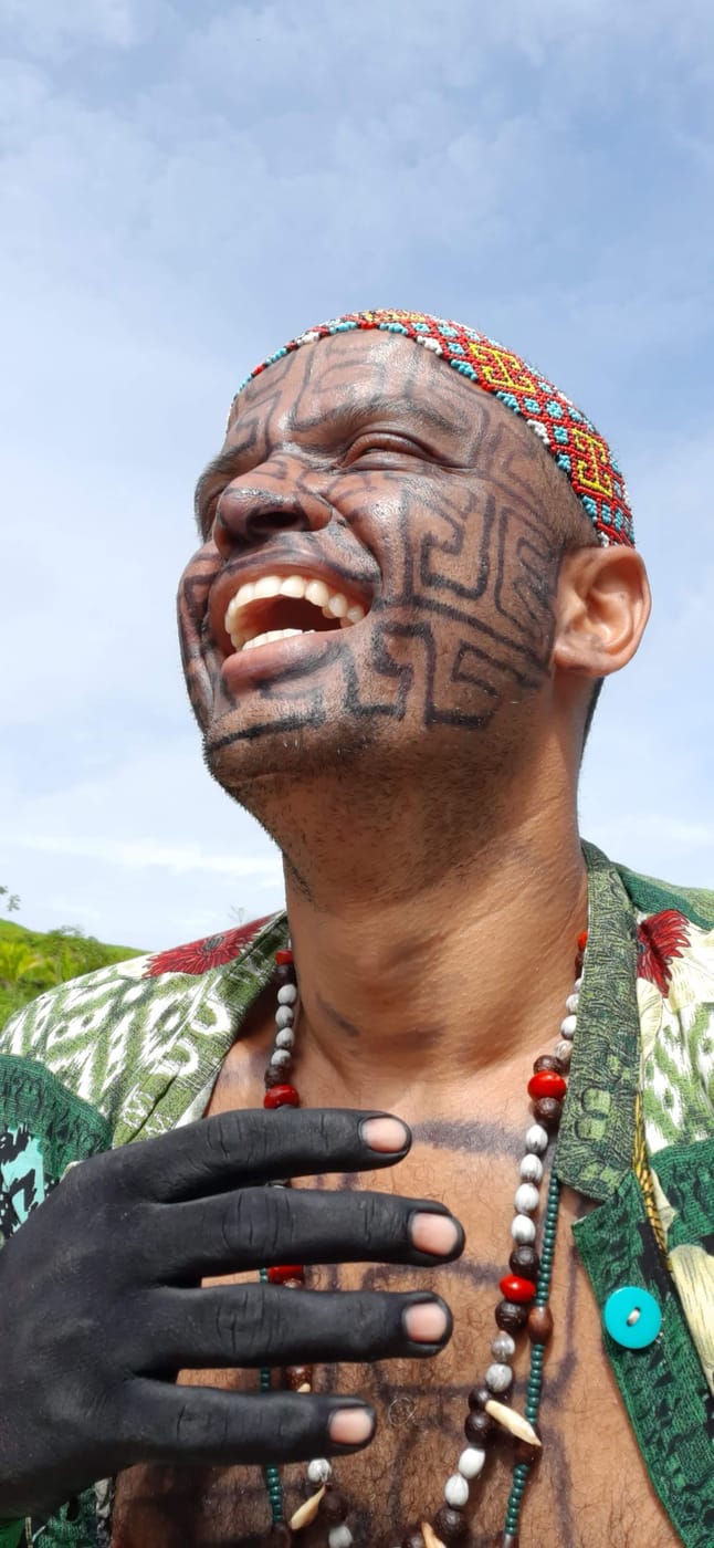 Rosto pintado com grafismo tradicional, sob o céu do Acre