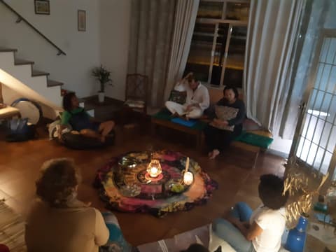Roda em sala com velas acesas e tapete ao centro