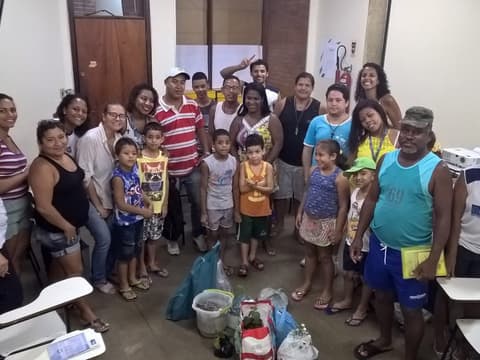 Grupo grande de adultos e crianças reunido em sala