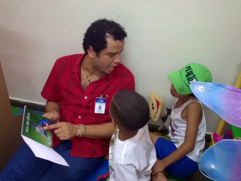Encontro com crianças em sala, com um livro nas mãos